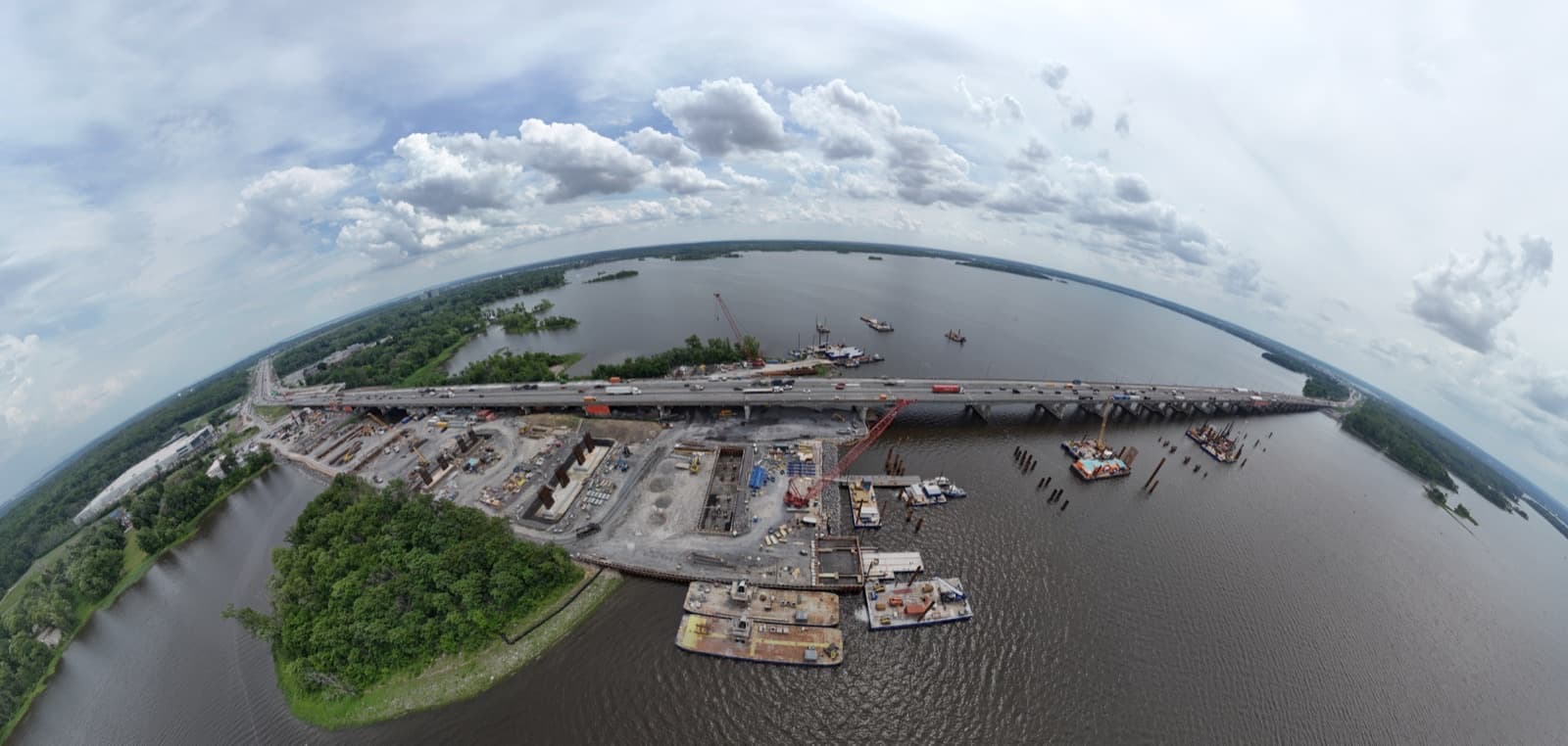 Vue aérienne du chantier de reconstruction du pont de l'Île-aux-Tourtes, avec barges et grues sur le lac des Deux Montagnes